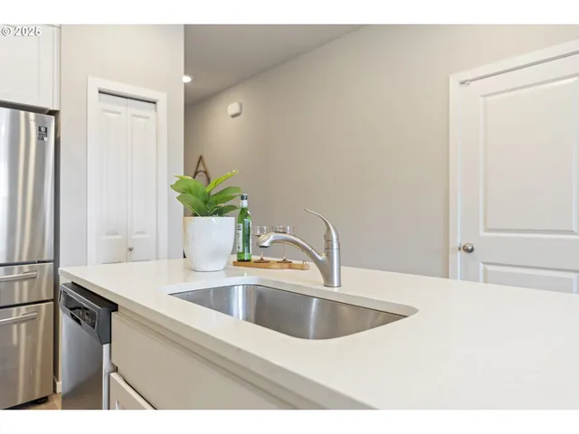 a close view of a sink and dishwasher with wooden floor