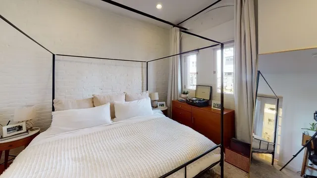 a bedroom with a large bed and a chandelier