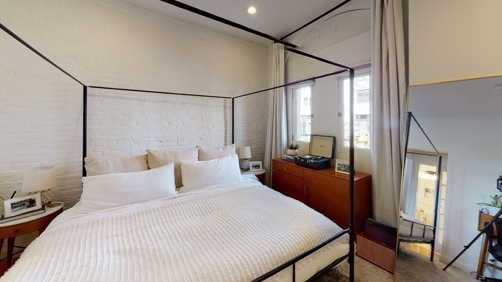 27 Bowdoin Street, Unit 1B Boston, MA 02114 - Photo 16 of 18 a bedroom with a large bed and a chandelier