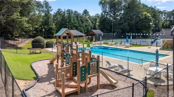 a view of a swimming pool with lawn chairs under an umbrella