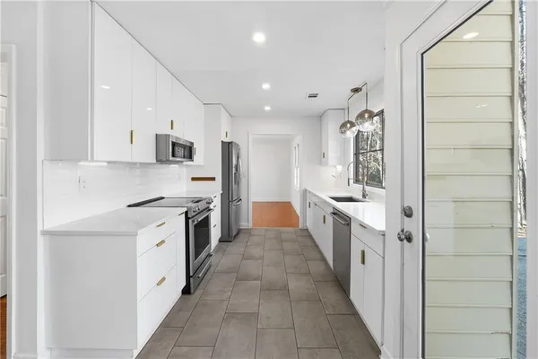 a large kitchen with stainless steel appliances granite countertop a large stove top oven and cabinets