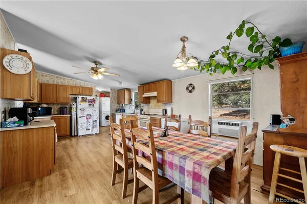 a dining room filled chandelier and wooden floor
