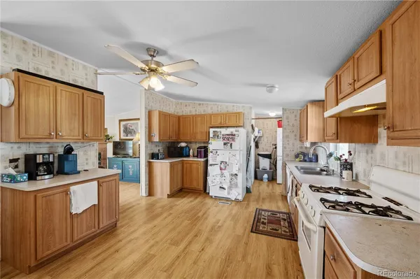 a kitchen with stainless steel appliances a stove a sink dishwasher and a refrigerator with wooden floor