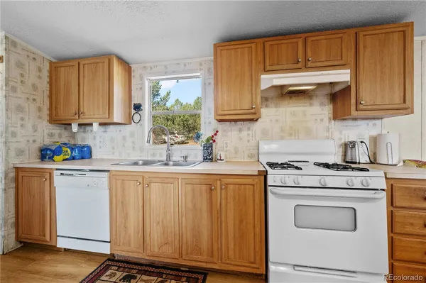 a kitchen with granite countertop wooden cabinets stainless steel appliances and a window