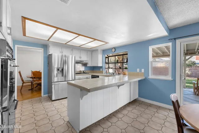 a kitchen with stainless steel appliances granite countertop a sink and a refrigerator