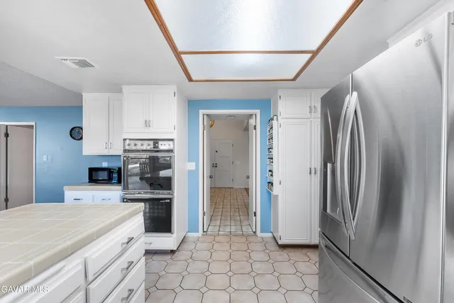 a kitchen with stainless steel appliances kitchen island granite countertop a refrigerator and a stove top oven