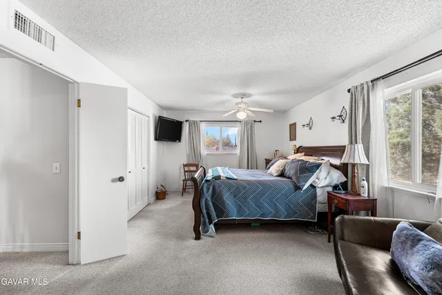 a view of a patio with table and chairs under an umbrella with a tree