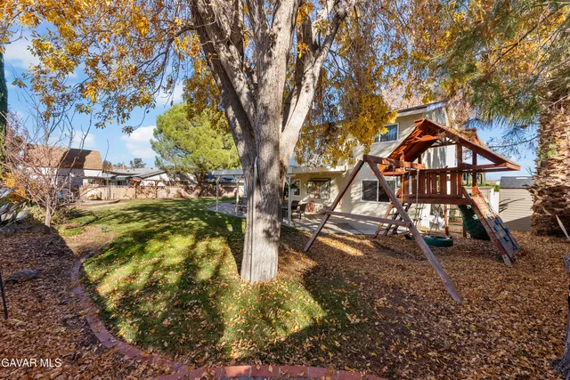 a view of a house with backyard and sitting area