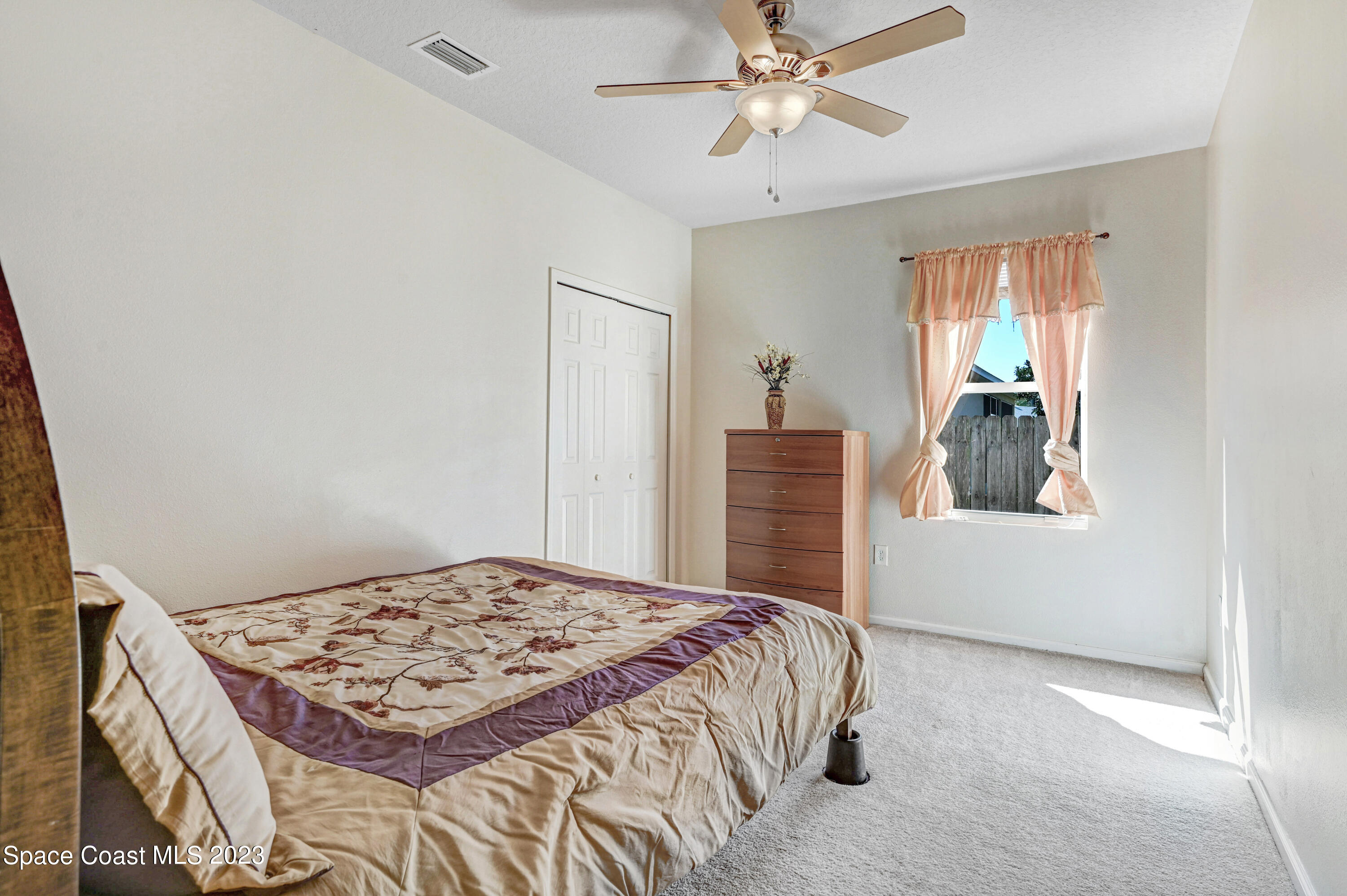 6720 Cairo Road Port St. John, FL 32927 - Photo 14 of 38 a bedroom with a bed and a chandelier