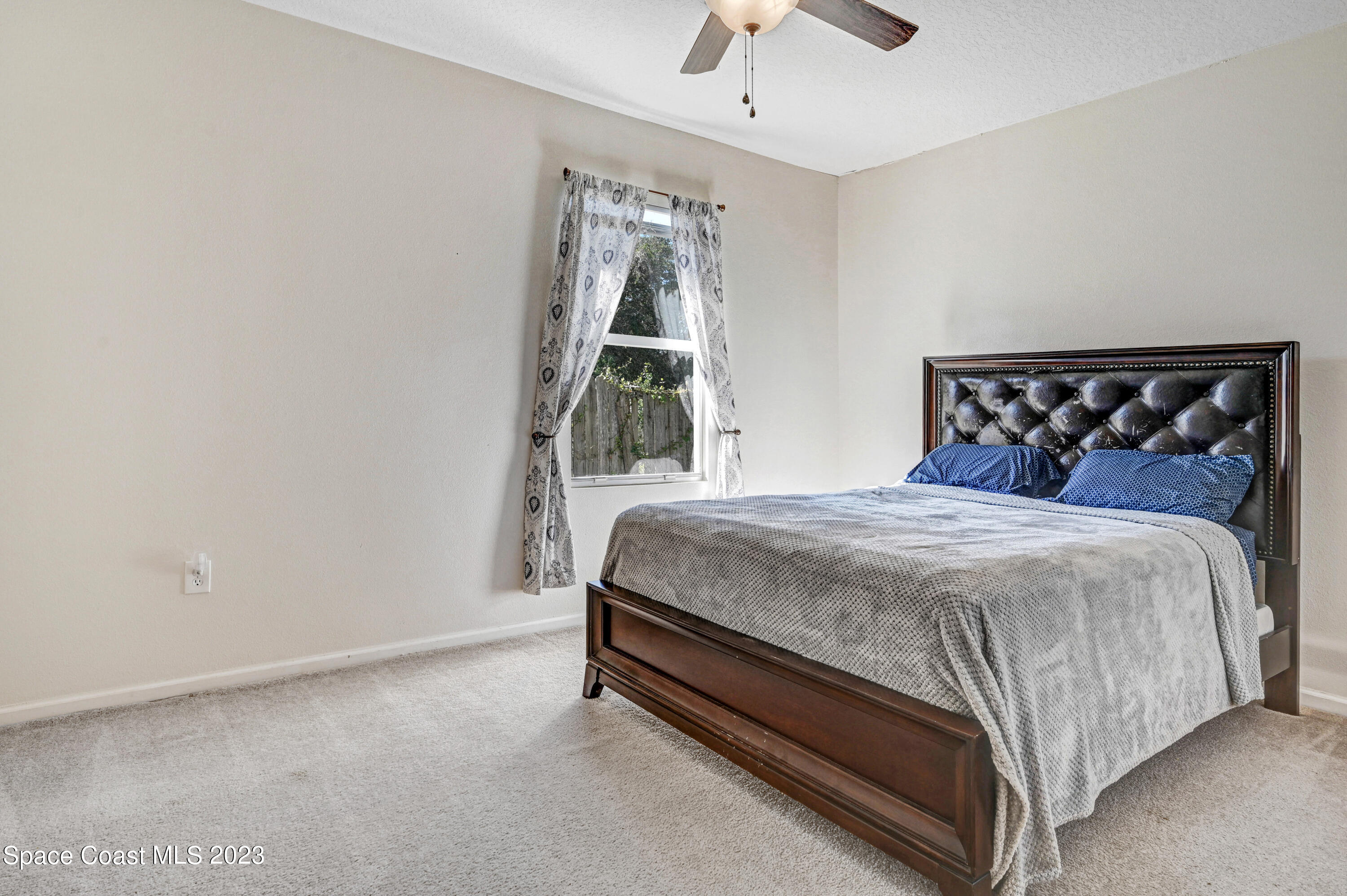 6720 Cairo Road Port St. John, FL 32927 - Photo 16 of 38 a bed sitting in a bedroom next to a window