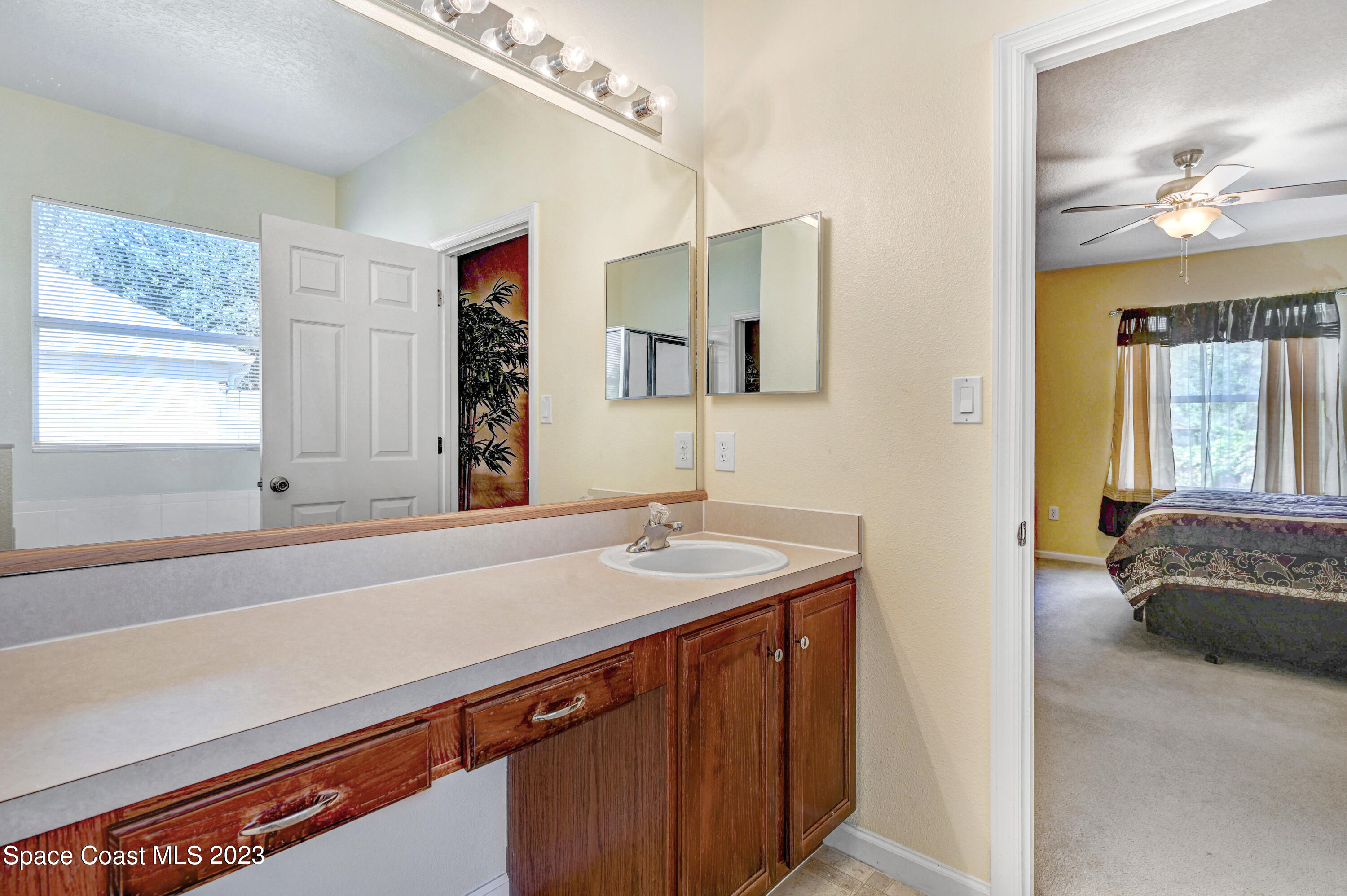6720 Cairo Road Port St. John, FL 32927 - Photo 28 of 38 a en suite bathroom with a sink and a mirror