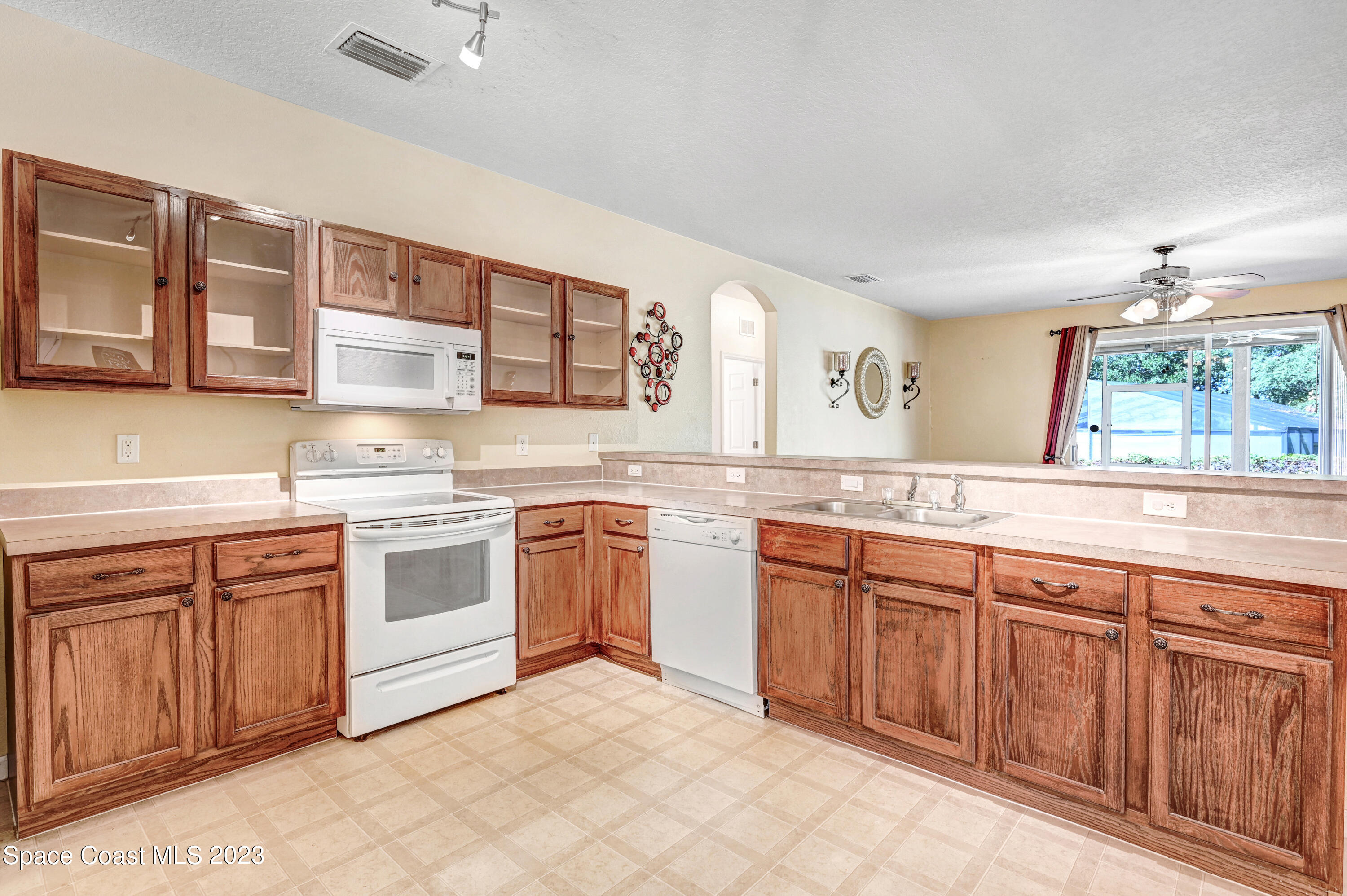 6720 Cairo Road Port St. John, FL 32927 - Photo 29 of 38 a kitchen with granite countertop a sink stainless steel appliances and cabinets