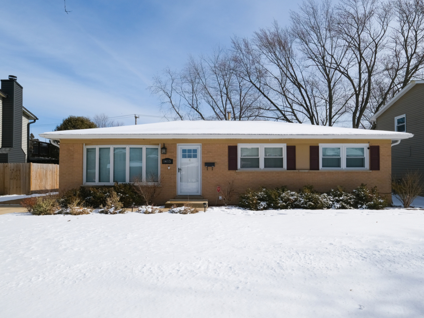 1415 South Chestnut Drive Mount Prospect, IL 60056 - Photo 1 of 15 a front view of a house with a yard covered in snow