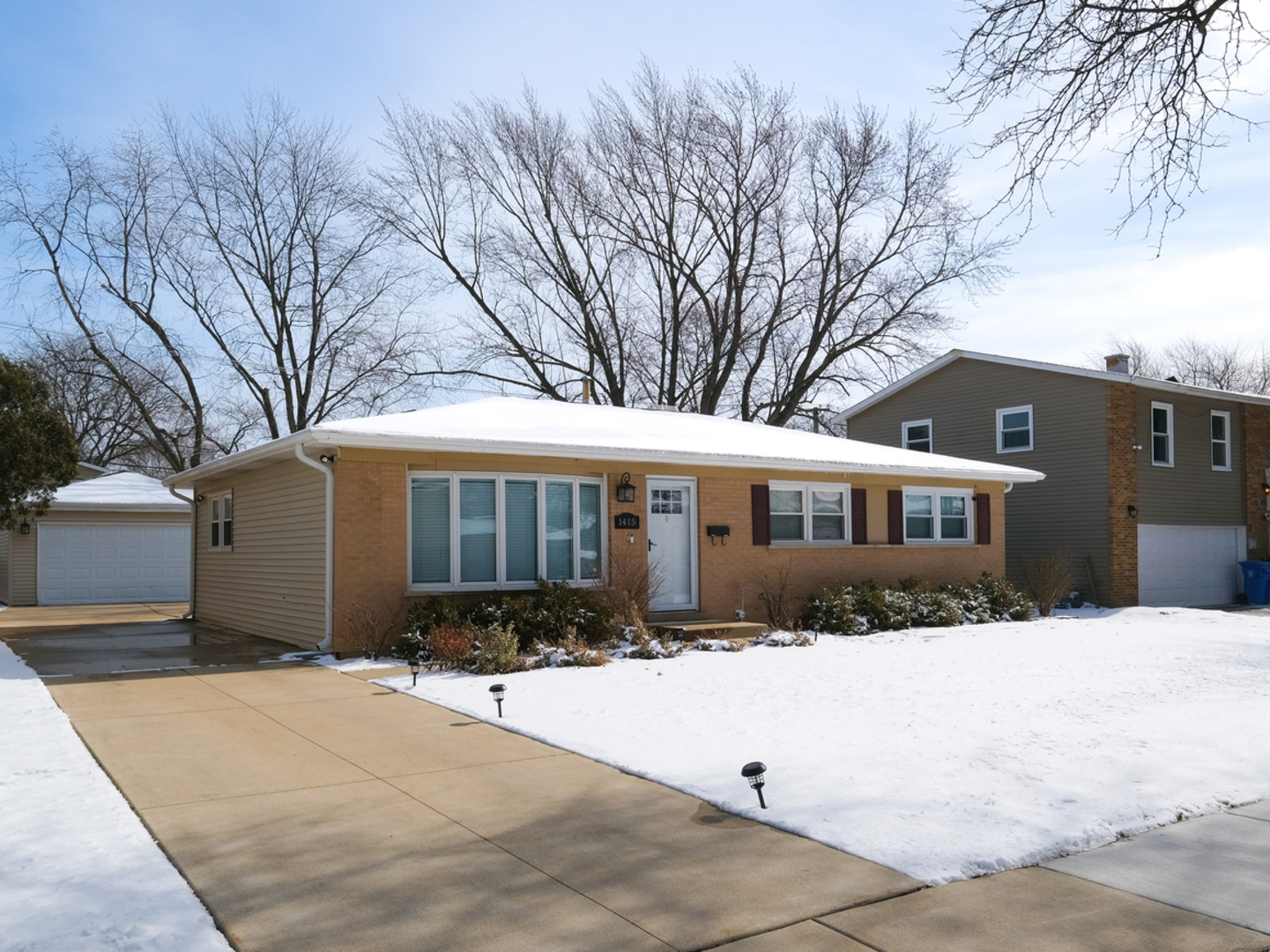 1415 South Chestnut Drive Mount Prospect, IL 60056 - Photo 2 of 15 a front view of a house with a yard covered in snow