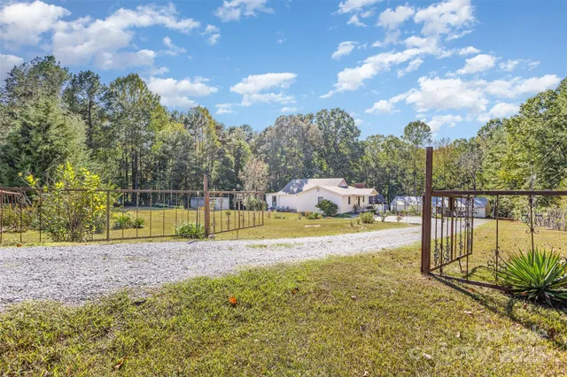 a view of a yard in front of a house with large tree