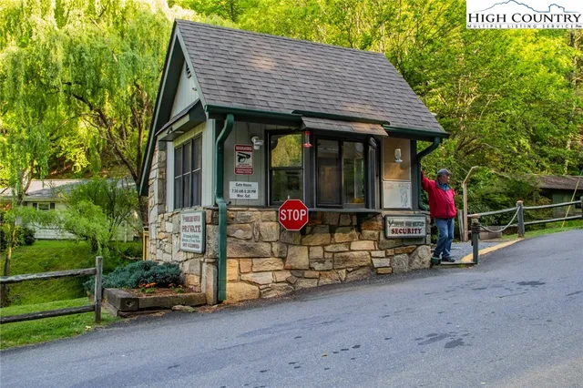 a view of a house that has a small yard and large trees