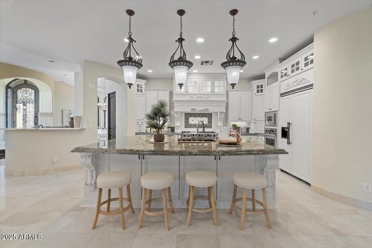 4037 North Pinnacle Hills Circle Mesa, AZ 85207 - Photo 18 of 195 a kitchen with stainless steel appliances kitchen island granite countertop a table and chairs in it