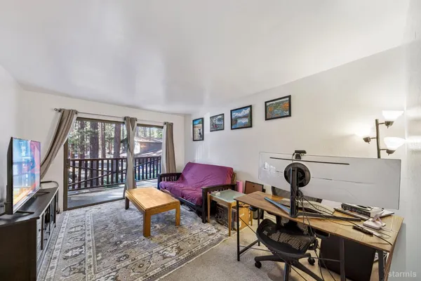 a living room with furniture a flat screen tv and a window