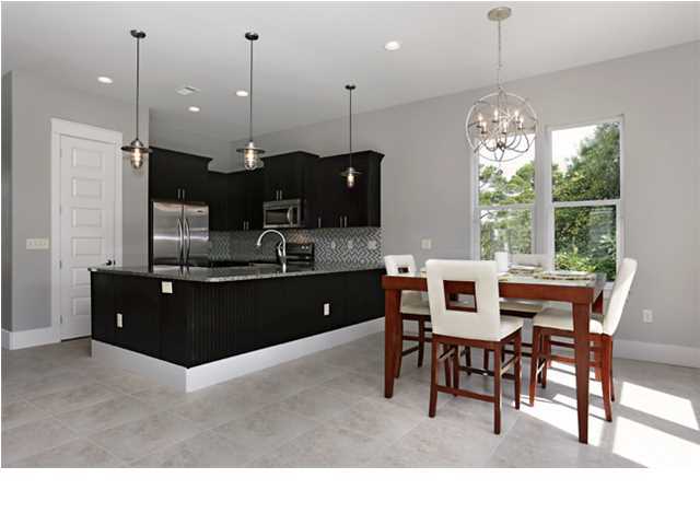 228 Miami Street Miramar Beach, FL 32550 - Photo 17 of 32 a kitchen with kitchen island stainless steel appliances a dining table chairs sink and white cabinets