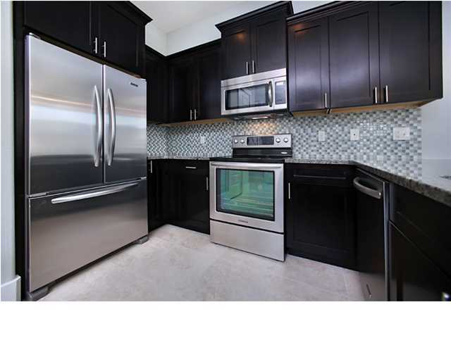 228 Miami Street Miramar Beach, FL 32550 - Photo 18 of 32 a kitchen with granite countertop stainless steel appliances and wooden cabinets