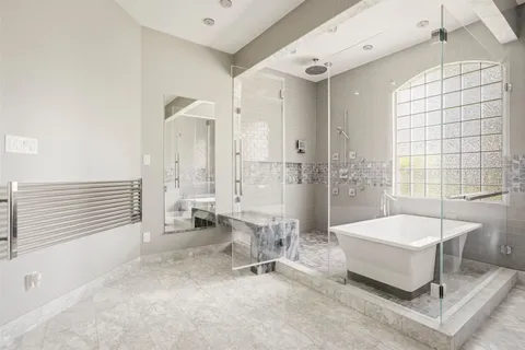 a spacious bathroom with a tub sink and mirror