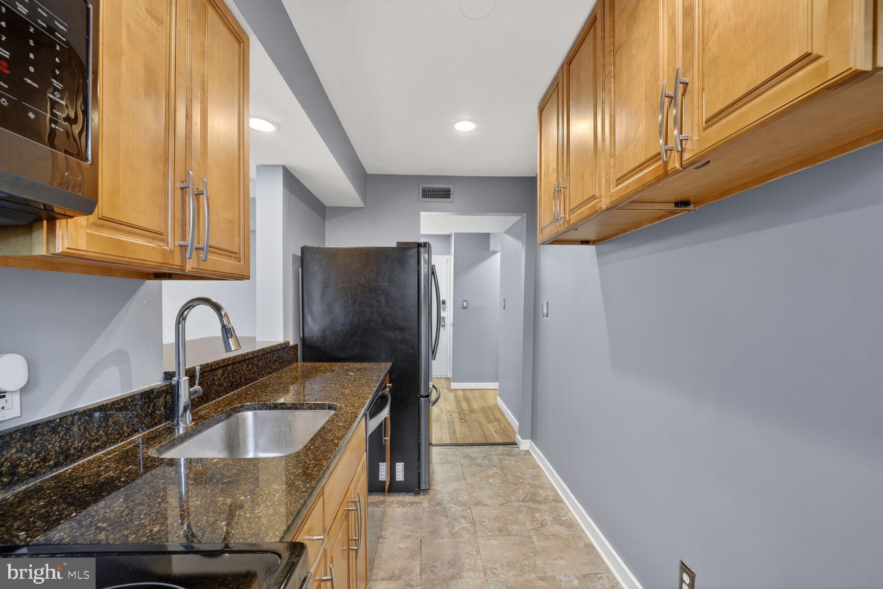 2248 Washington Avenue, Unit 101 Silver Spring, MD 20910 - Photo 12 of 23 a kitchen with granite countertop a sink a stove and refrigerator