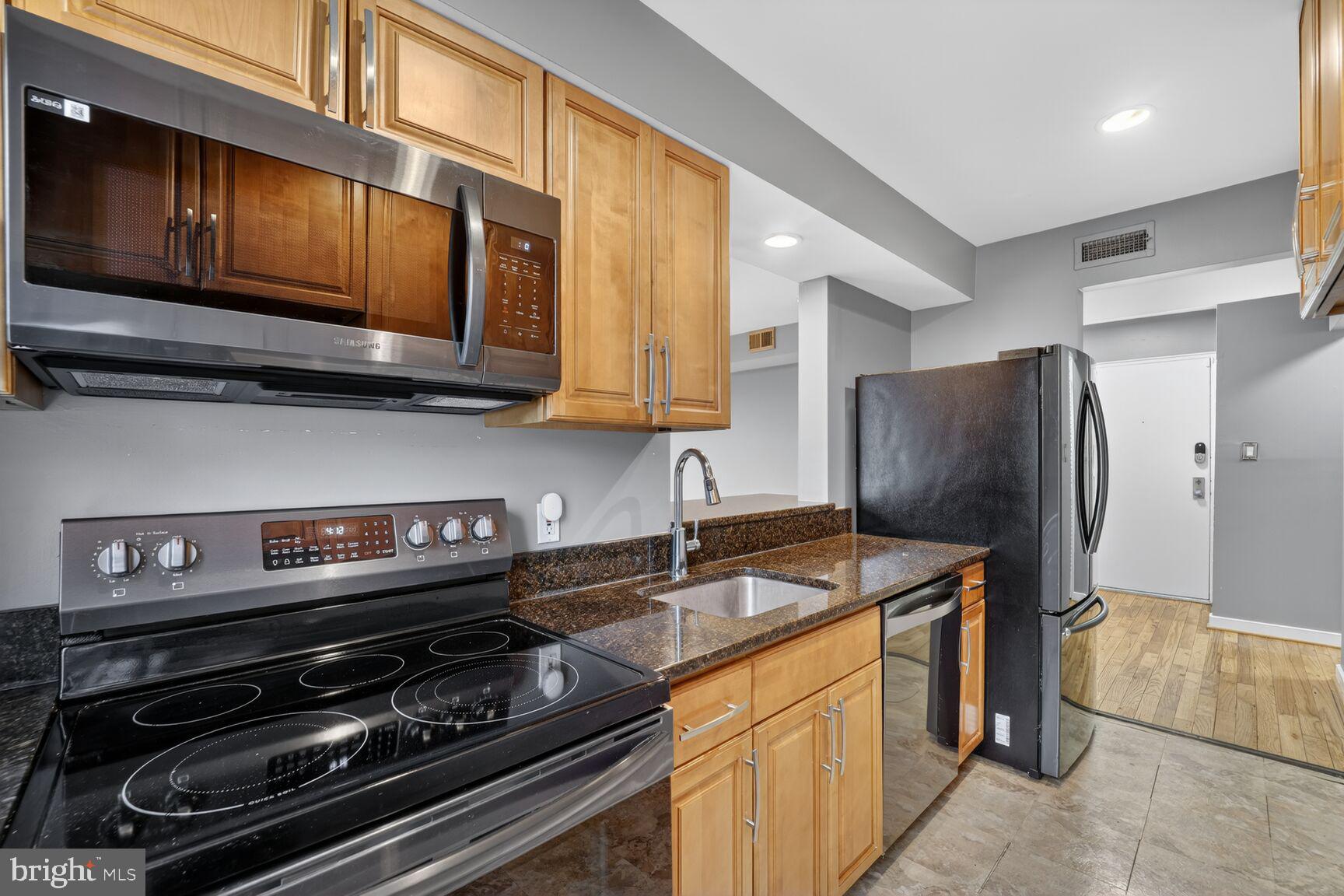 2248 Washington Avenue, Unit 101 Silver Spring, MD 20910 - Photo 13 of 23 a kitchen with stainless steel appliances granite countertop a stove microwave and refrigerator