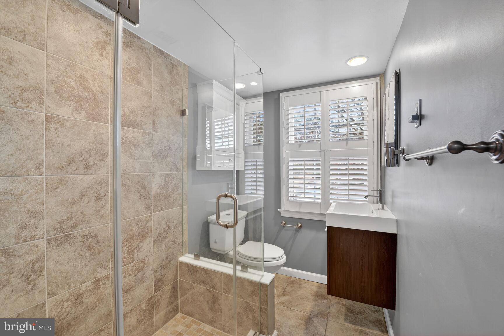 2248 Washington Avenue, Unit 101 Silver Spring, MD 20910 - Photo 21 of 23 a bathroom with a granite countertop sink a toilet and shower