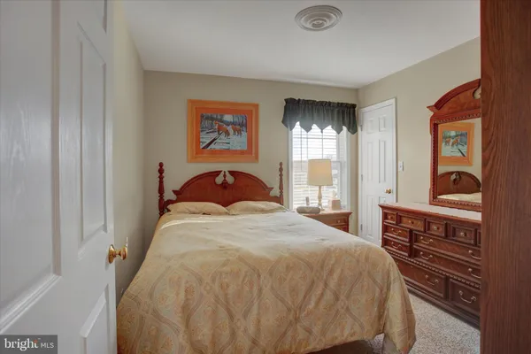 a bedroom with a bed and dresser with mirror