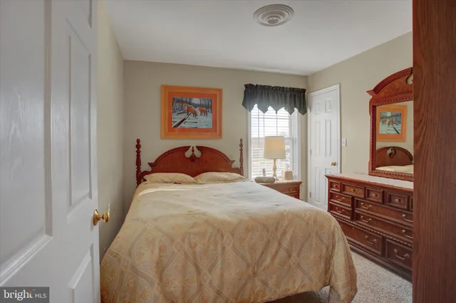 a bedroom with a bed and dresser with mirror