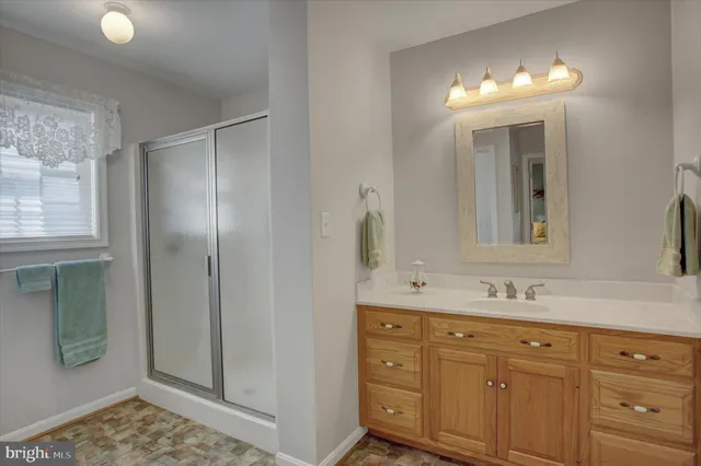 a bathroom with a double vanity sink and mirror with shower