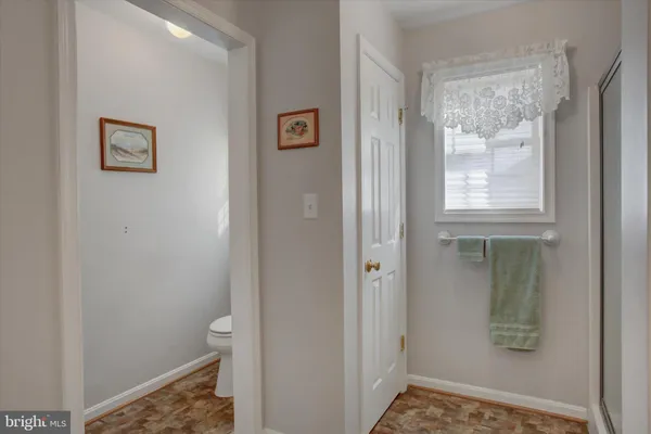 a view of hallway with window and a bathroom