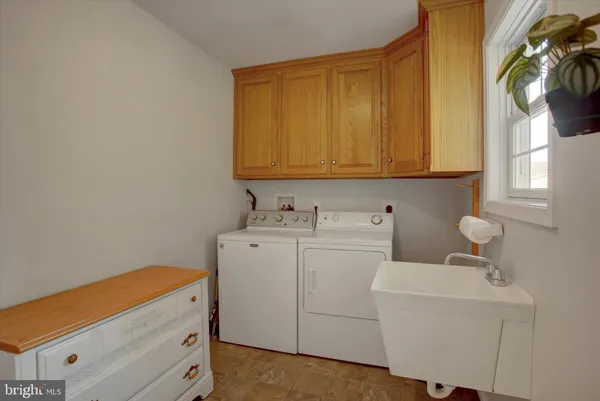a living room with furniture a flat screen tv and kitchen view
