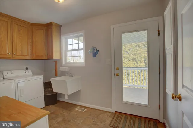 a living room with furniture a flat screen tv and kitchen view