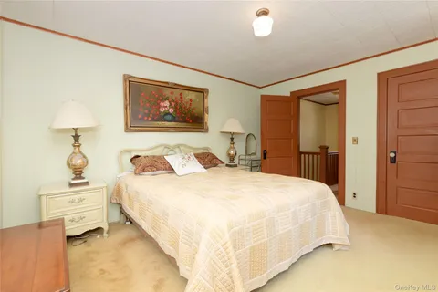 a bedroom with a bed and a lamp on dresser