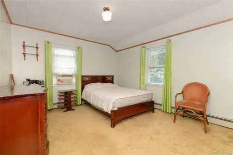 a bedroom with a bed chair and a large window