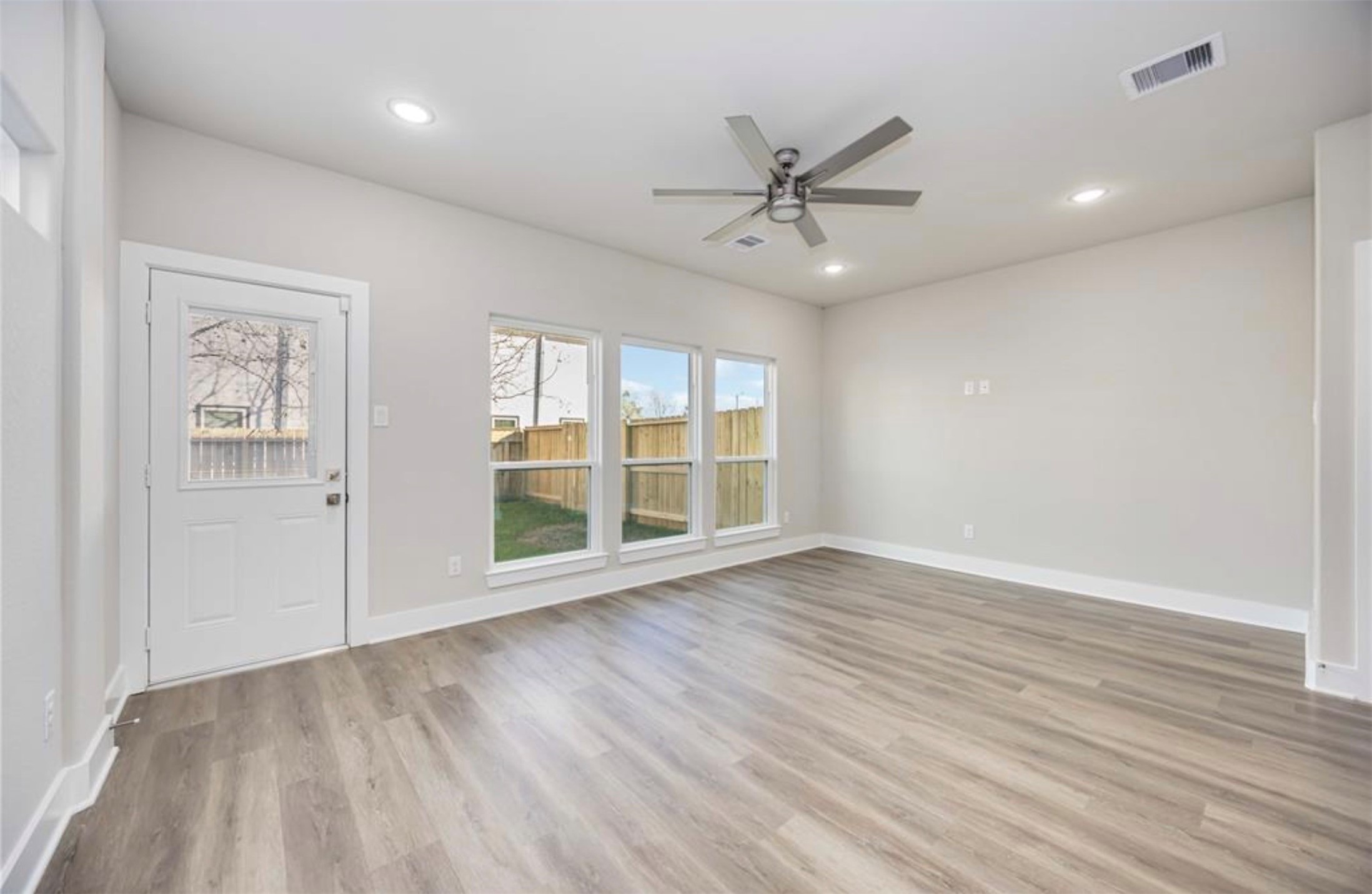 415 Gans Street, Unit AB Houston, TX 77029 - Photo 11 of 24 an empty room with wooden floor fan and windows