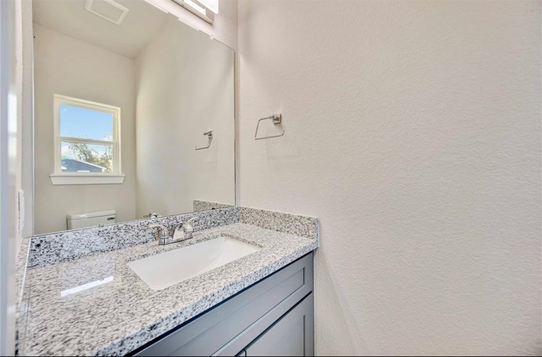 415 Gans Street, Unit AB Houston, TX 77029 - Photo 5 of 24 a bathroom with a granite countertop sink and a mirror