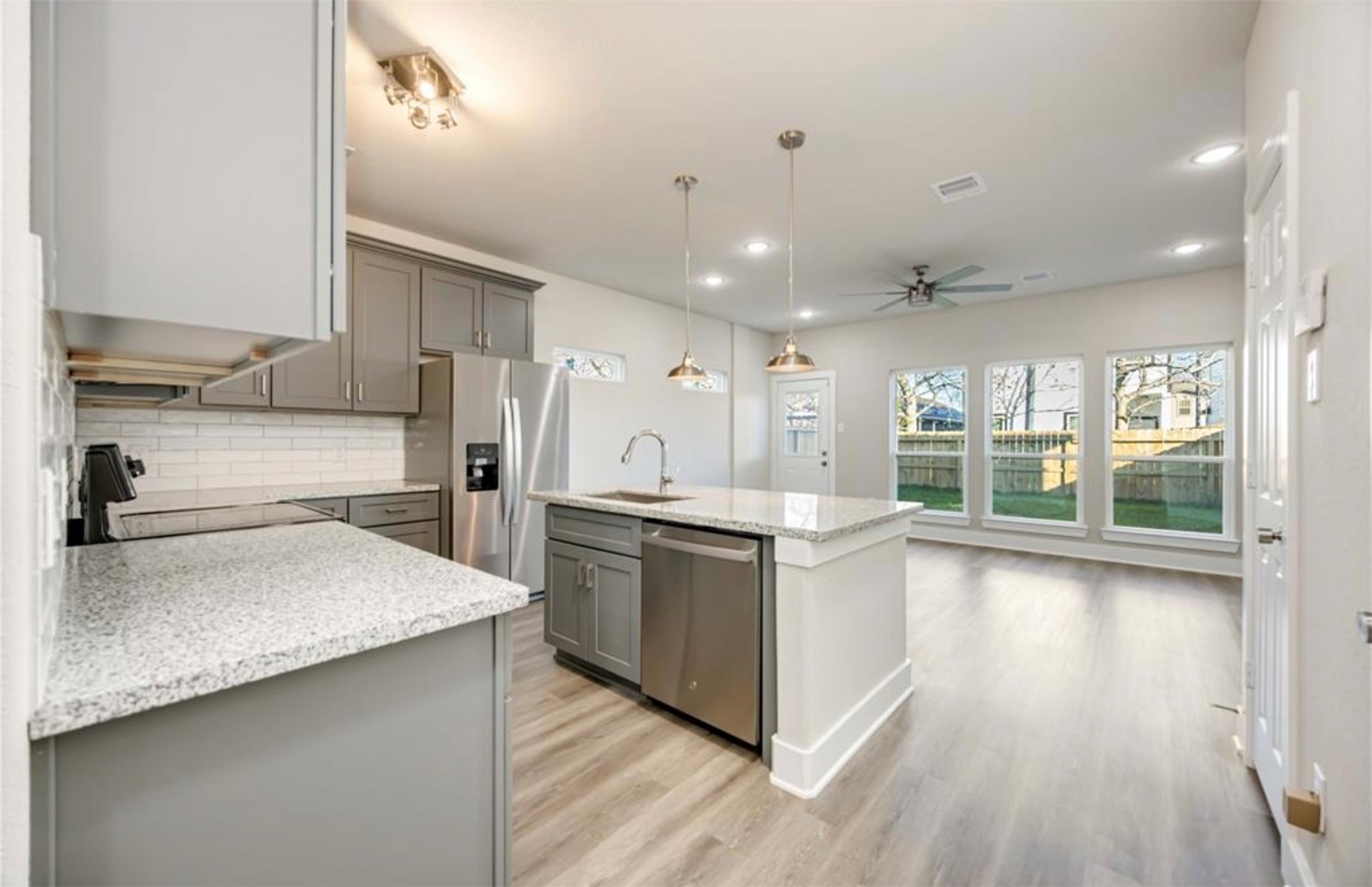 415 Gans Street, Unit AB Houston, TX 77029 - Photo 6 of 24 a large kitchen with stainless steel appliances kitchen island a large counter top and wooden floors