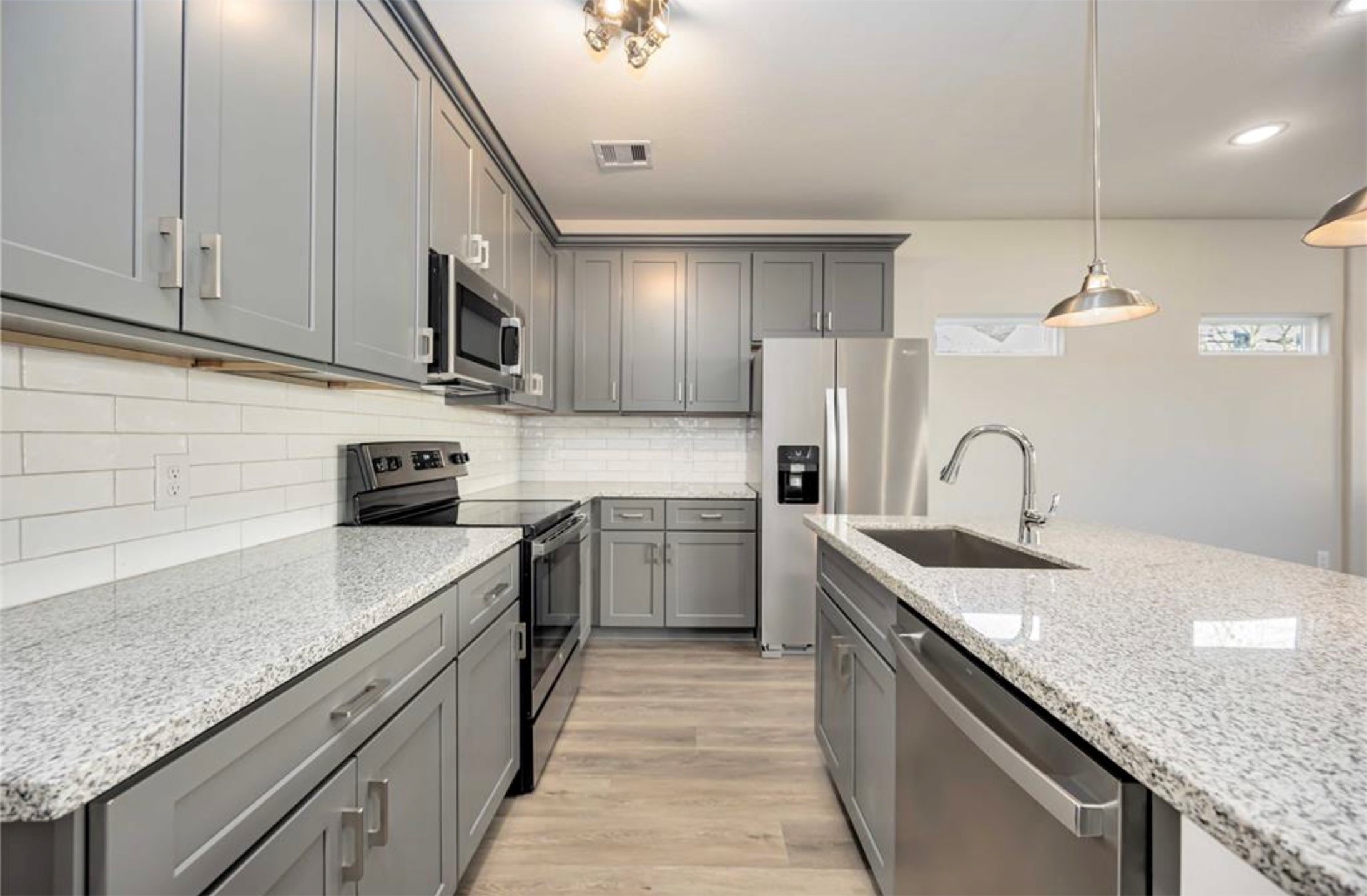 415 Gans Street, Unit AB Houston, TX 77029 - Photo 7 of 24 a kitchen with granite countertop a sink stainless steel appliances and cabinets