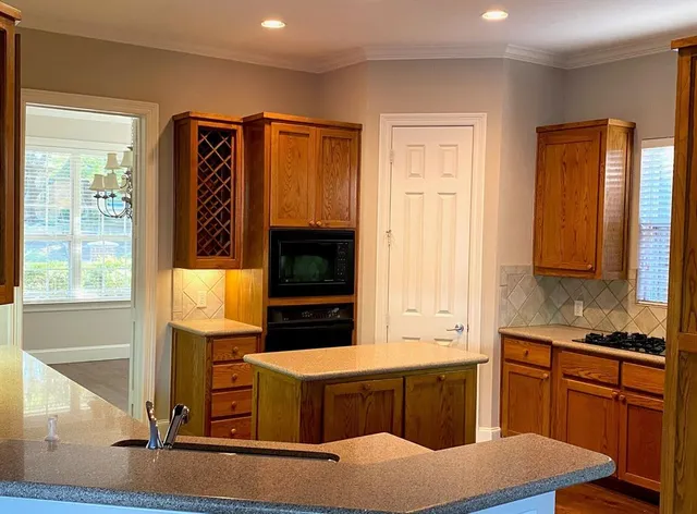 a kitchen with stainless steel appliances granite countertop a stove a sink and a microwave