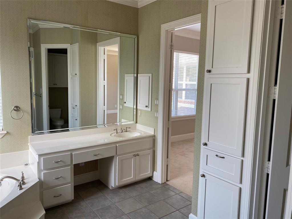 2605 Tulip Drive Richardson, TX 75082 - Photo 21 of 30 a bathroom with a double vanity sink a mirror and a bathtub