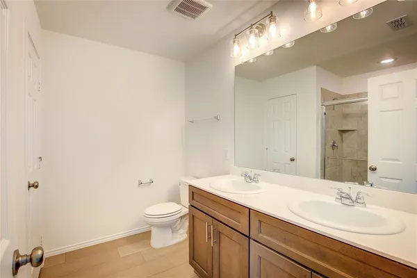 a spacious bathroom with a granite countertop sink a toilet and a mirror