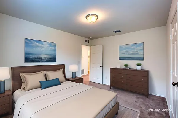 a bedroom with a bed and a lamp on dresser