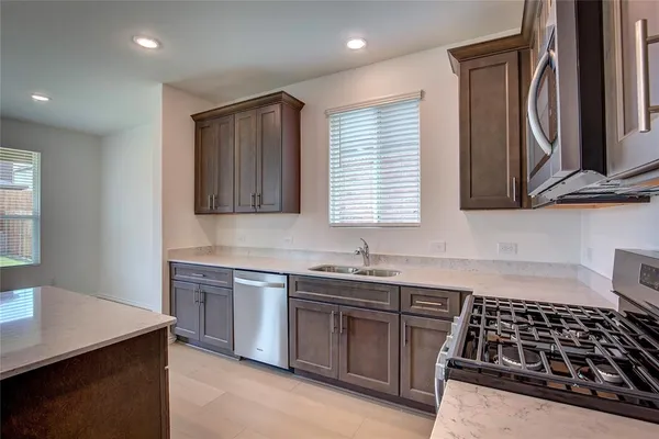 a kitchen with granite countertop a sink stove and cabinets