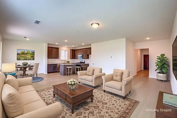 a living room with furniture kitchen view and a potted plant