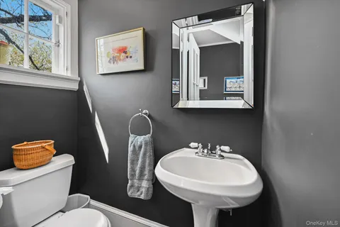 a bathroom with a toilet sink and mirror