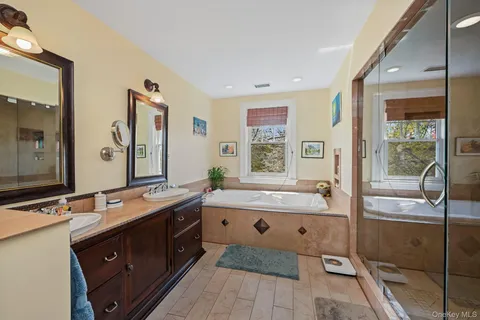 a bathroom with a bathtub sink and mirror