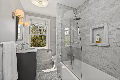 a bathroom with a granite countertop sink a toilet and shower