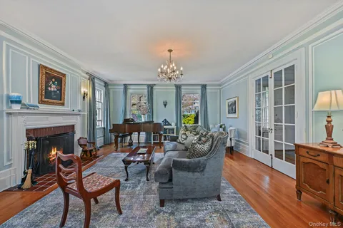 a living room with furniture a chandelier and a fireplace